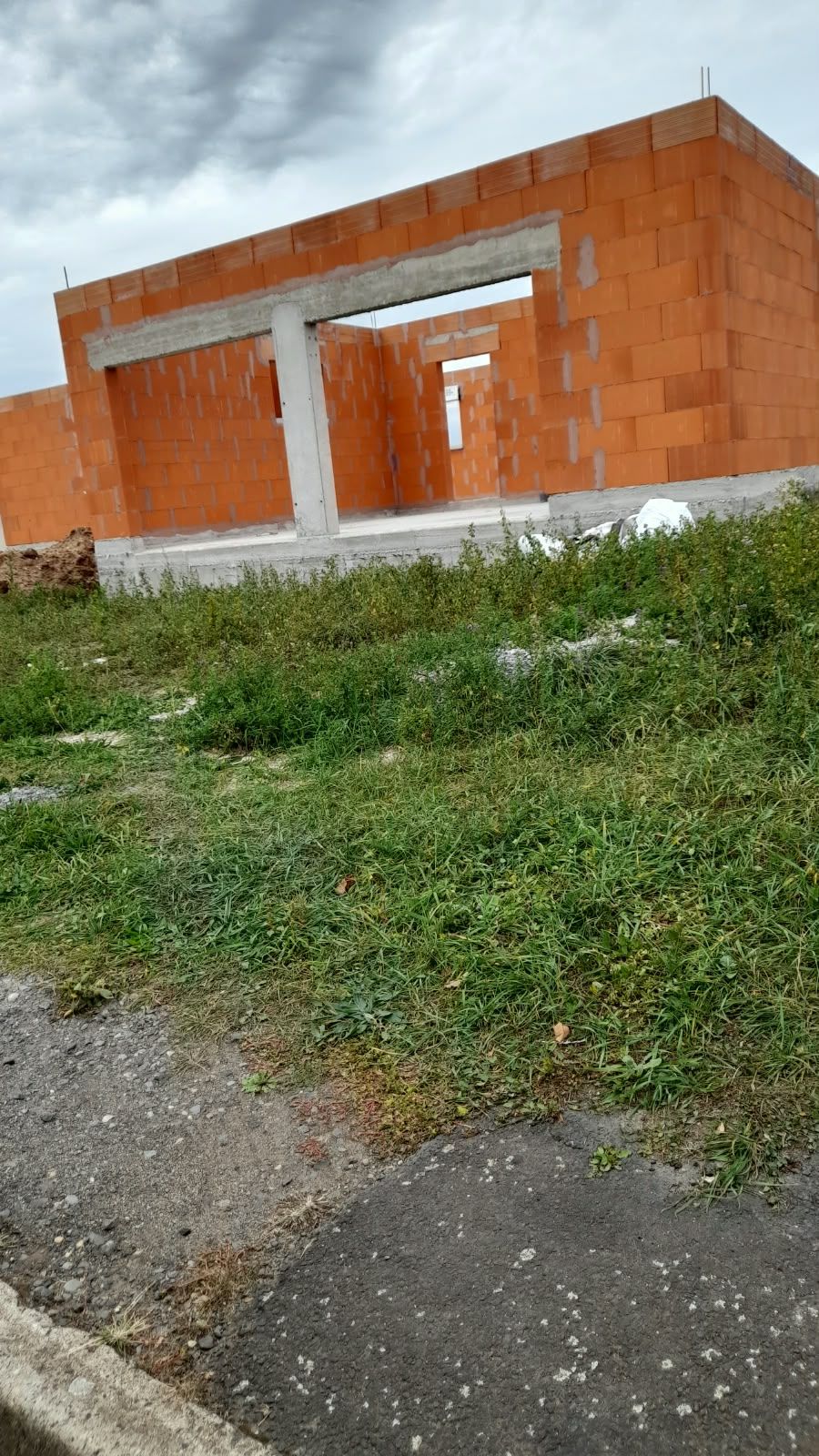 Murs en brique rouge montés avec poteau et grand linteau en béton au-dessus d'une ouverture