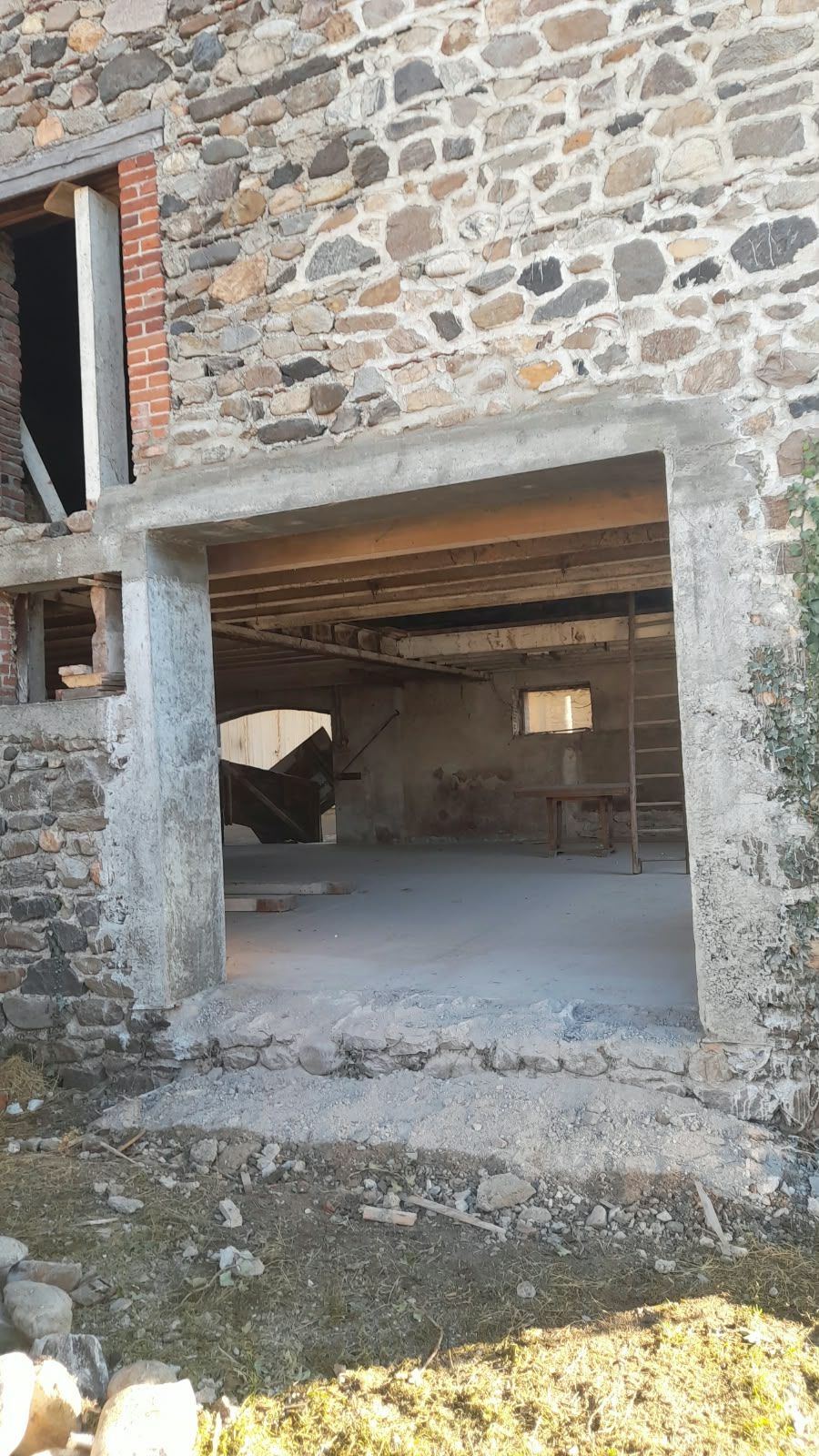 Encadrement en béton d'une ouverture dans un vieux mur en pierre
