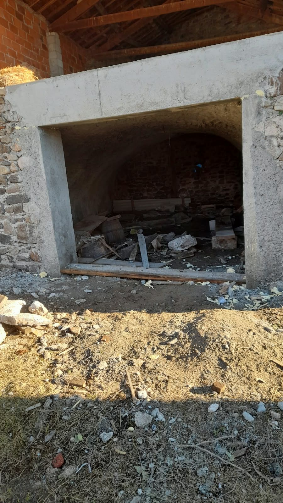 Grande ouverture créée dans un mur en pierre, avec encadrement en béton