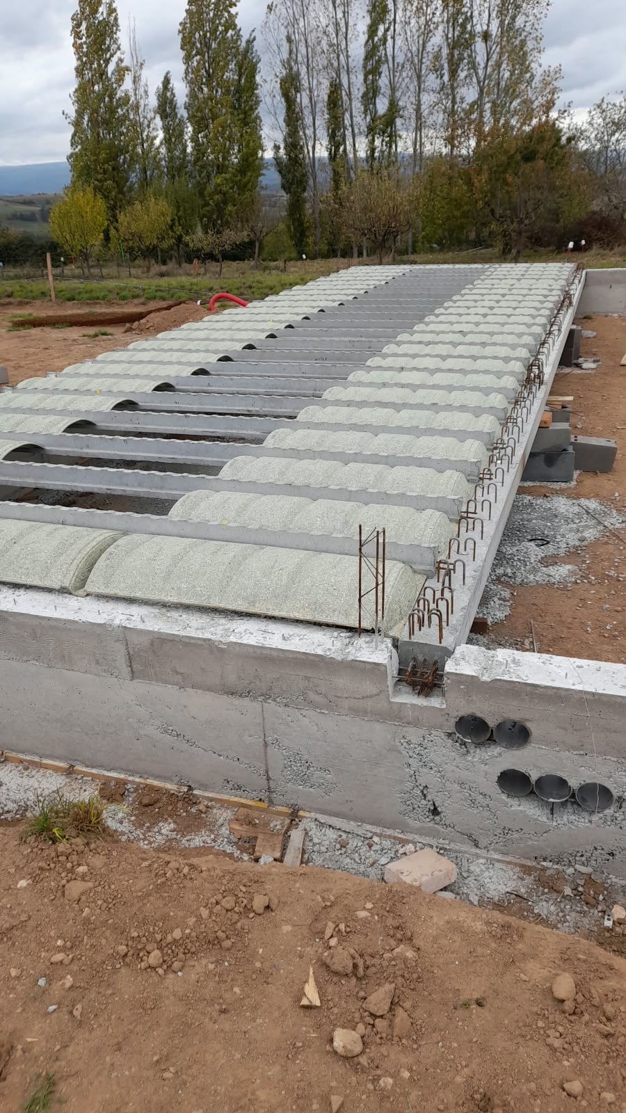 Plancher en poutrelles béton et hourdis posé sur un soubassement en béton