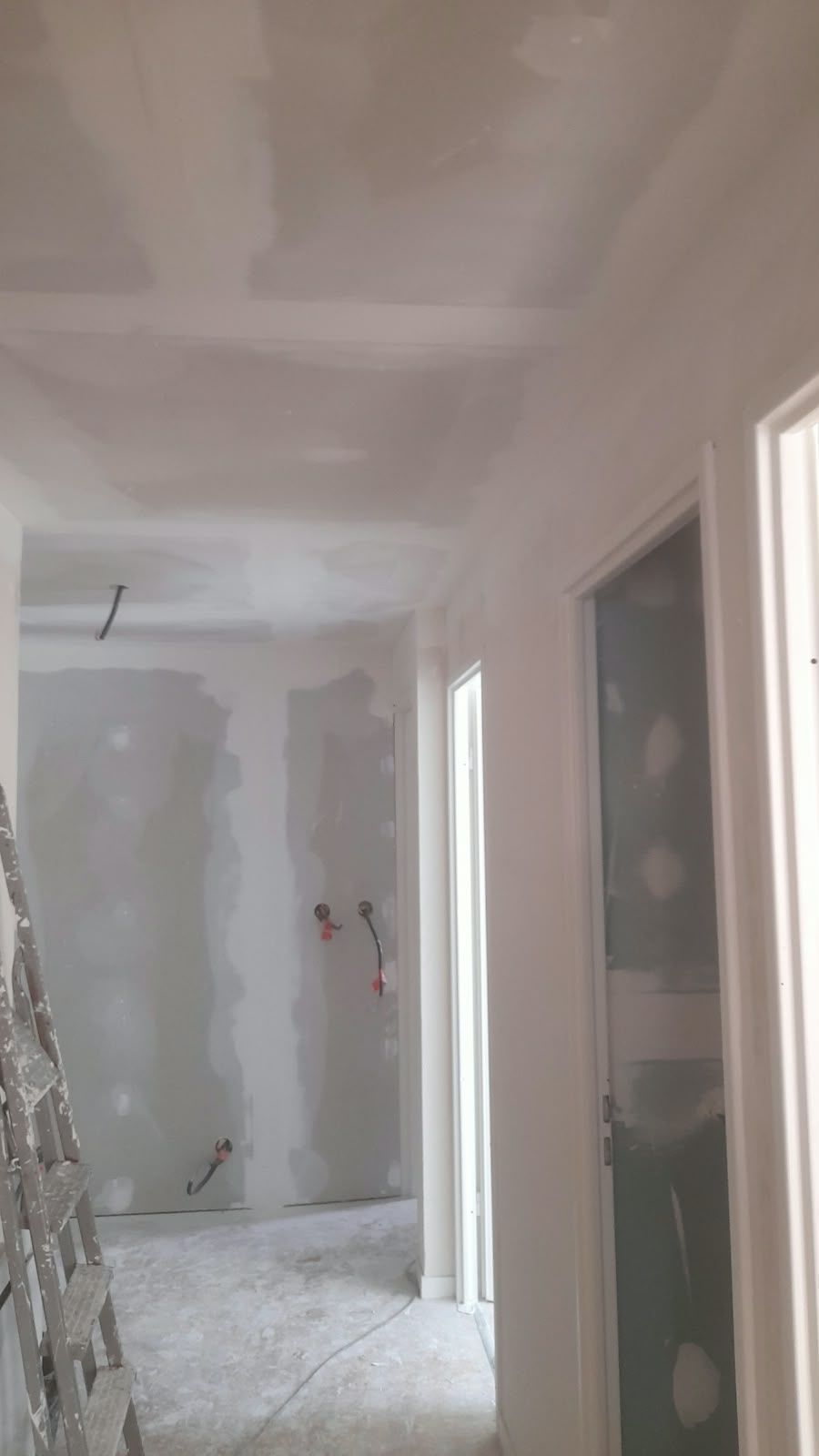 Couloir prêt pour la peinture : Murs et plafond lissés, finitions soignées.