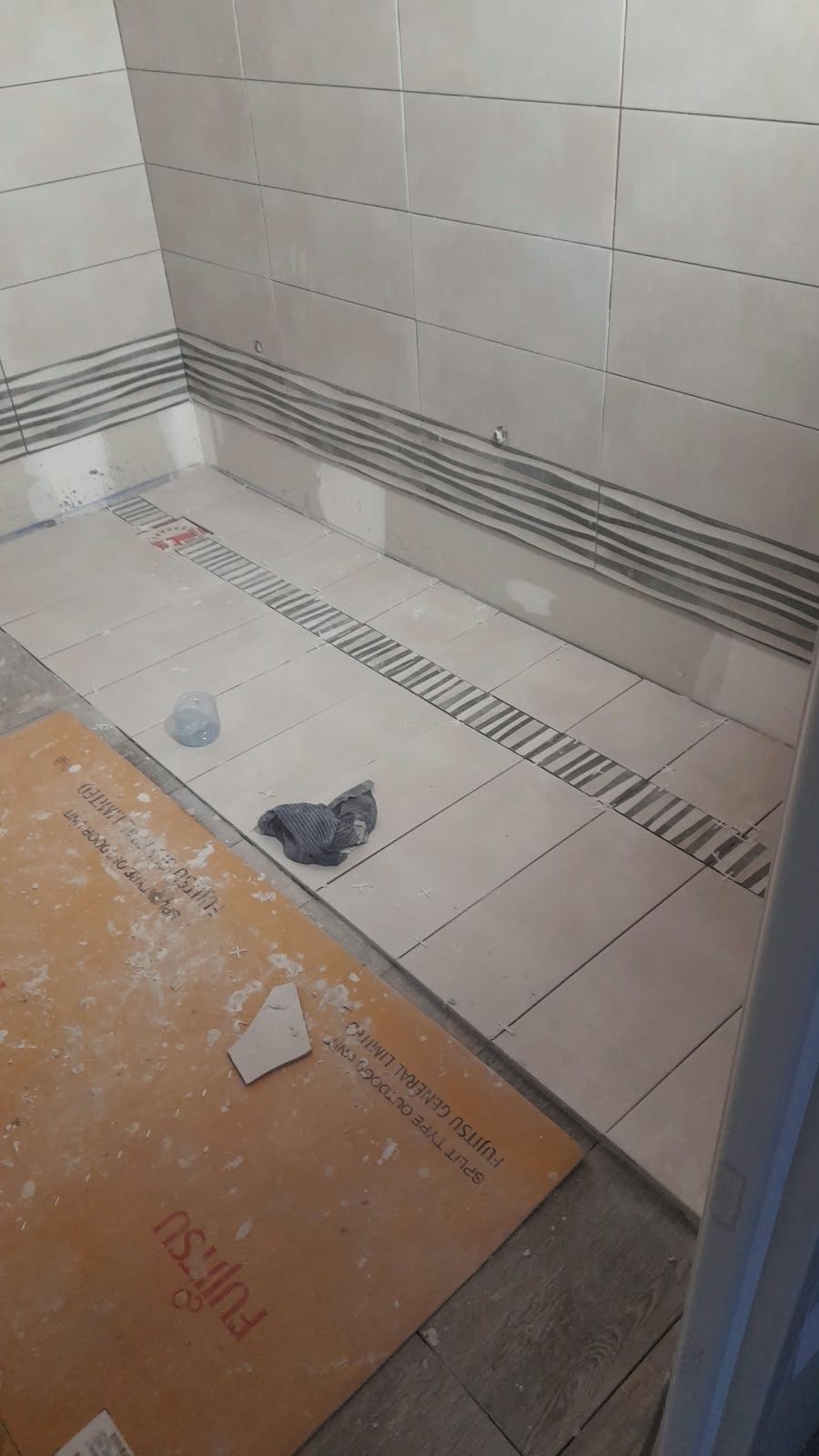 Douche de plain-pied : Carrelage et frise jusque dans la douche.