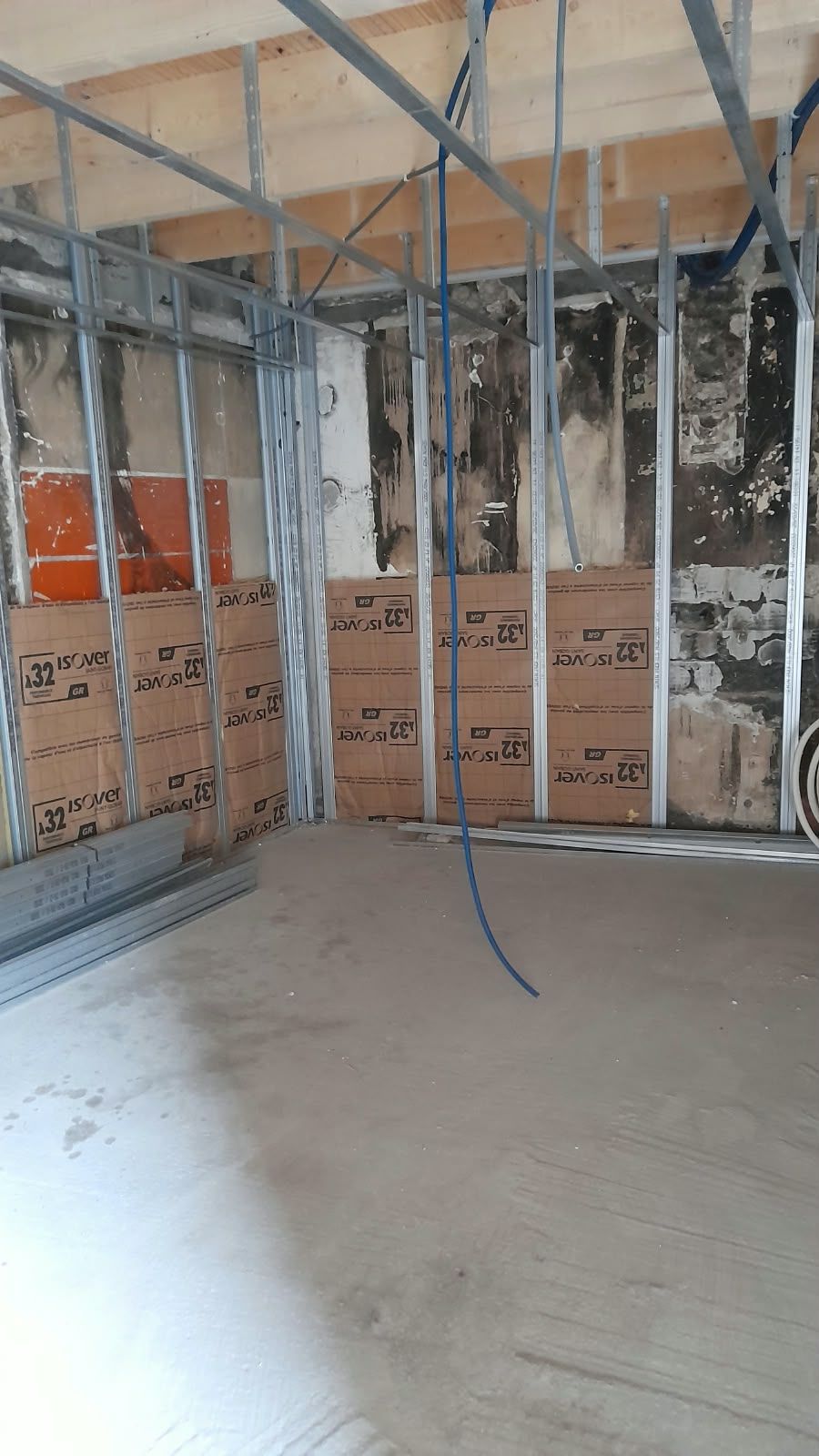 Cloisons sur ossature métallique : Rails posés et isolant en place avant les plaques.