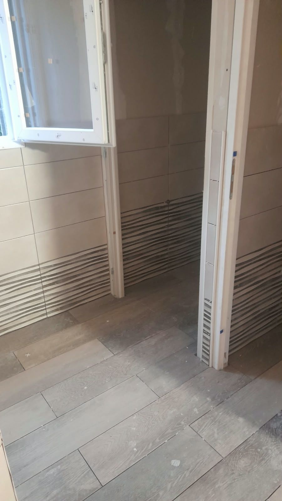 Salle de bain carrelée : Sol et murs finis, alignements soignés.
